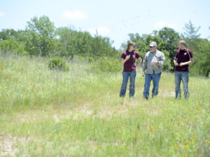 Professor and students in field