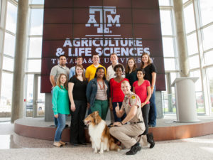 Students posing in front of a large screen in the AgriLife Center