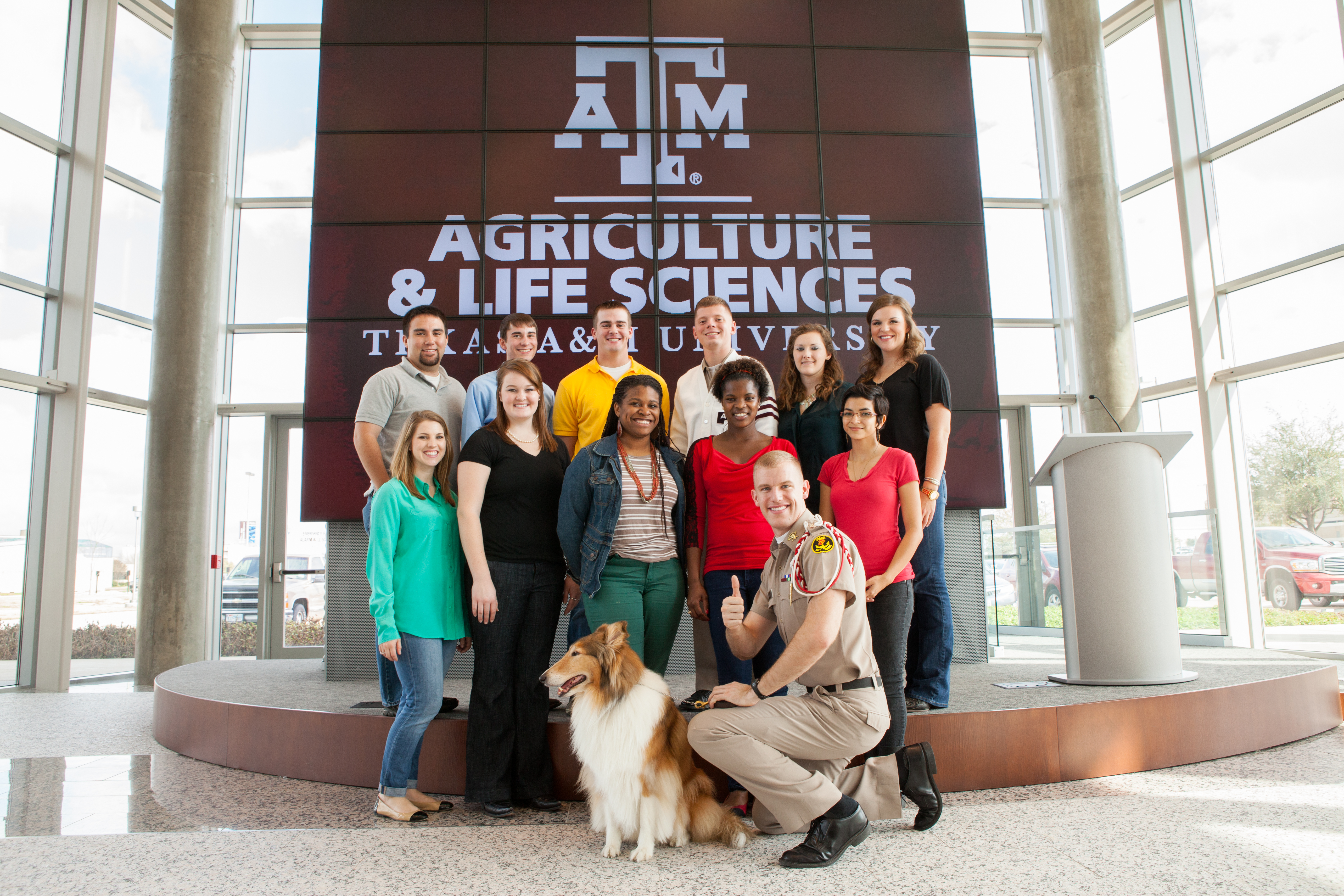 Students posing in front of a large screen in the AgriLife Center