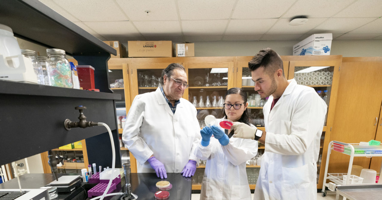 Two students in the food science lab with a faculty member
