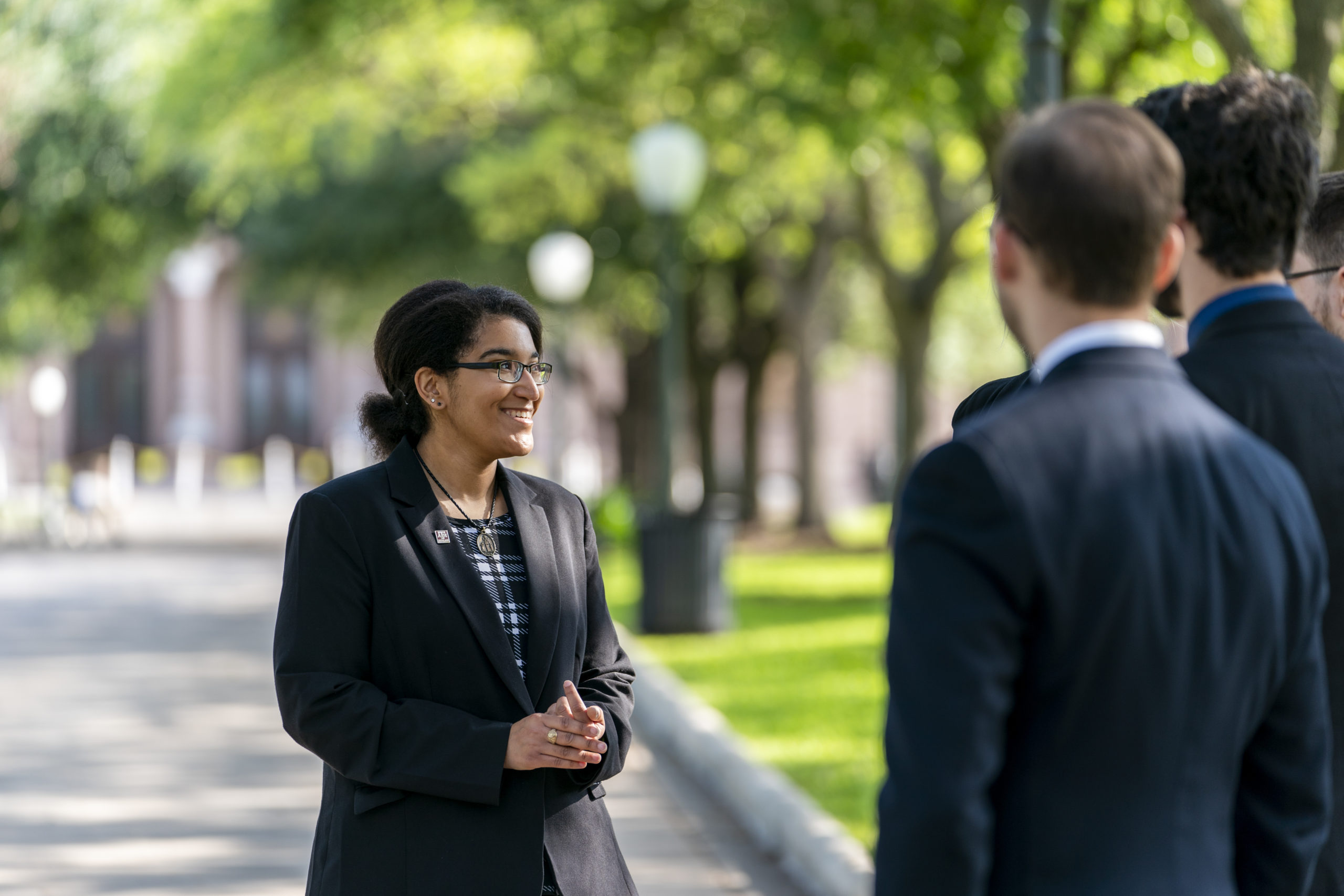 Student in suit talking to other students