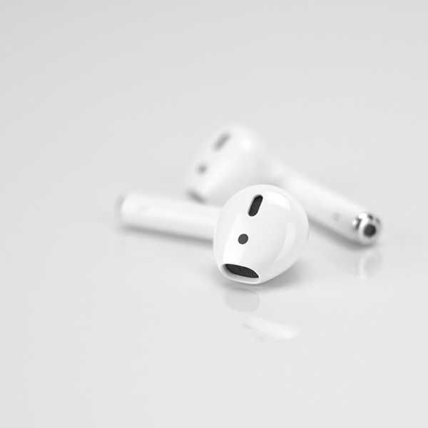 Two Earpods sitting on flat surface