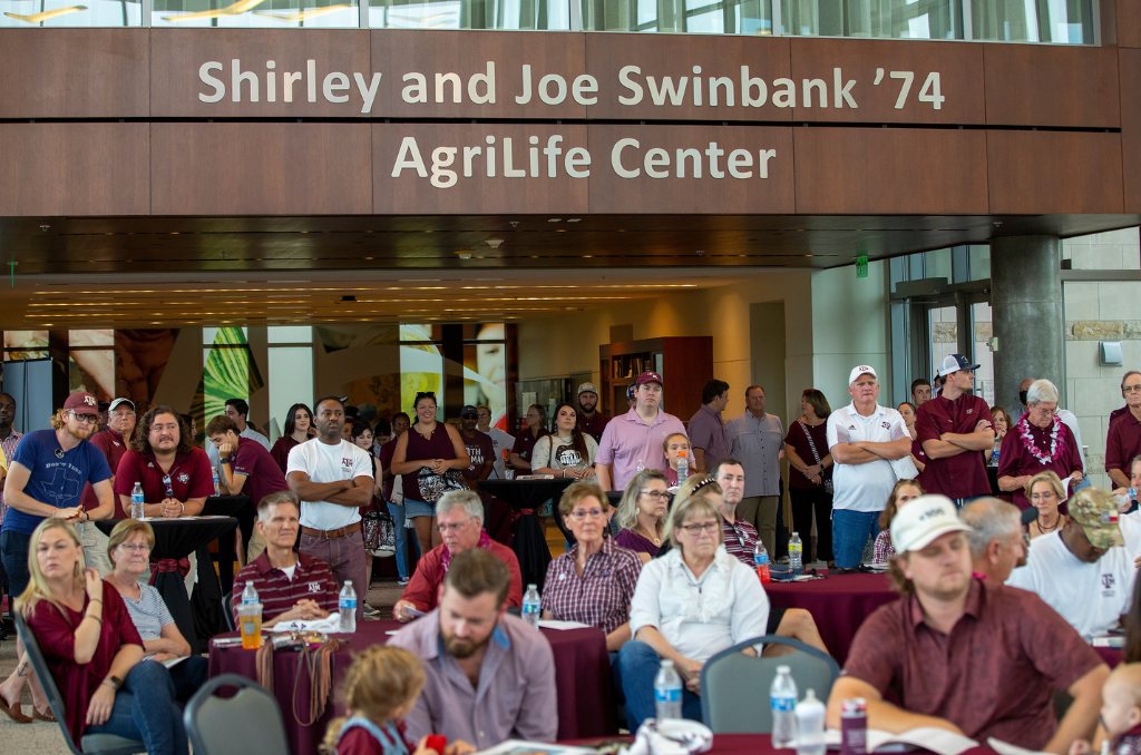 Group of people sitting and standing in the Shirley and Joe Swinbank '74 AgriLife center