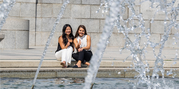 Two female interns by a fountain
